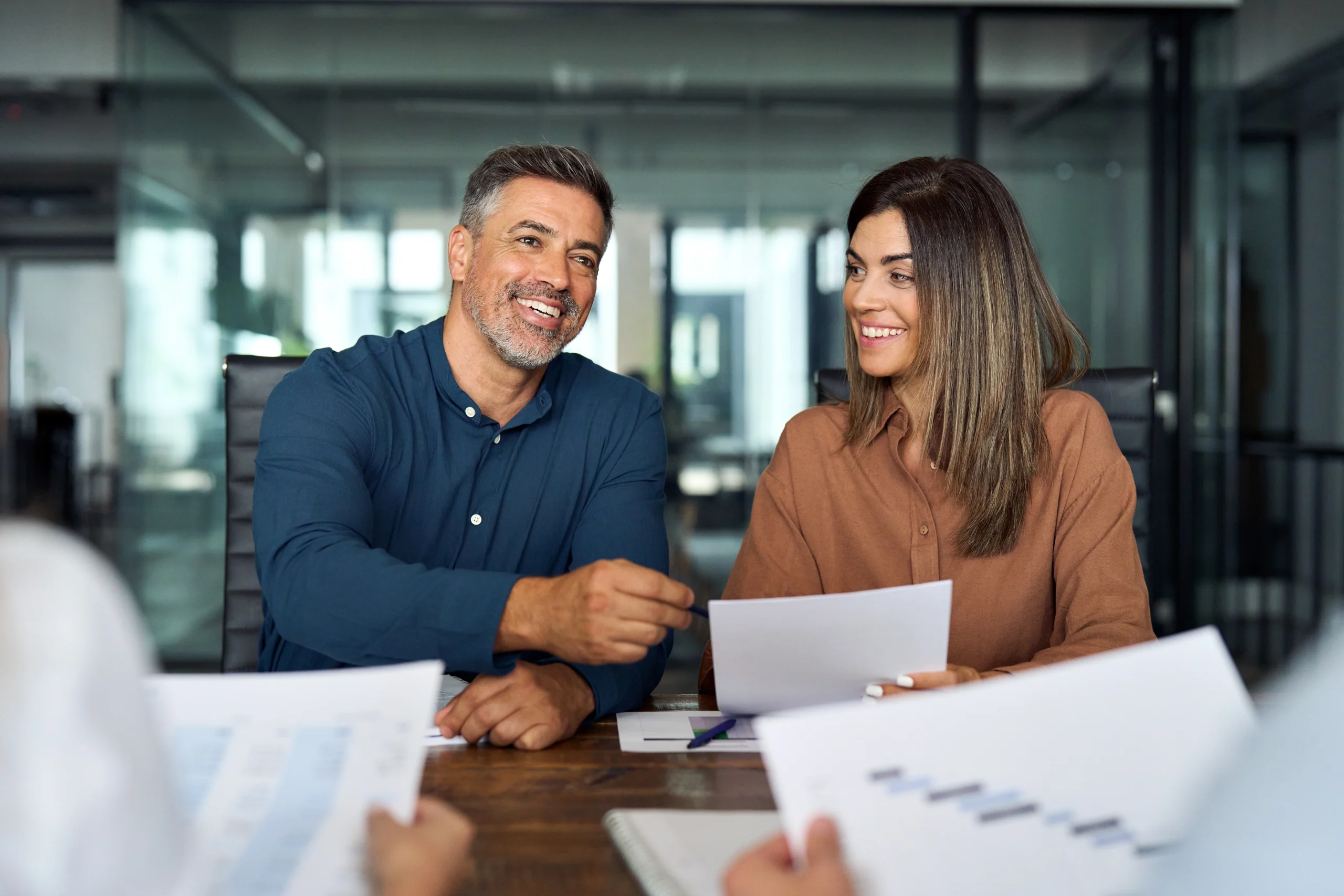 Accounting professionals discuss documents together at a table